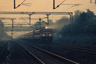 A high-speed train on a railway track during sunset.